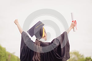 Graduate put her hand up and celebrating with certificate in her hand and feeling so happiness