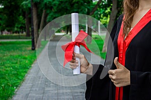 Graduate put her hands up and celebrating with certificate in her hand and feeling so happiness in Commencement day