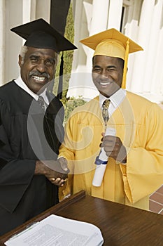 Graduate shaking hand of dean at podium photo