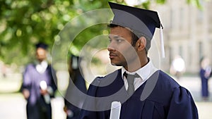 Graduate student looking into distance, nobody congratulating him, loneliness