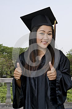 Graduate student outdoors with two thumbs up