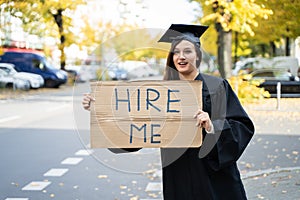 Graduate Student Standing With Hire Me Placard