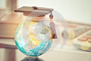 Graduate study abroad concept, Graduation cap on top Earth globe