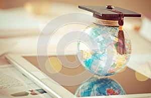 Graduate study abroad concept, Graduation cap on top Earth globe model map on laptop with Radar background. Graduate study abroad