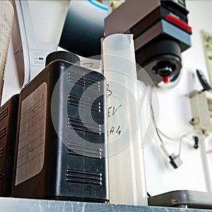 Graduated cylinder, black plastic bottles and photographic enlarger