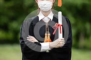 Graduated woman wear cap gown and Medical mask for protection virus holding diploma or certificated due Virus outbrake