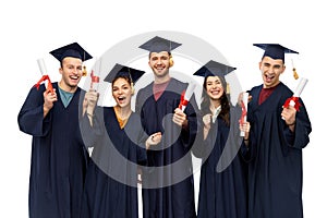 Graduates in mortar boards with diplomas