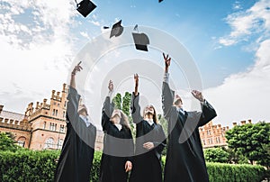 Graduates near university are throwing up hats in the air.