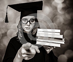 Graduating student girl in an academic gown with books