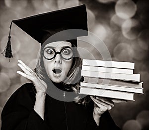 Graduating student girl in an academic gown with books