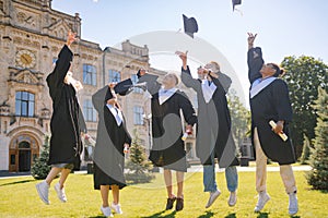 Graduating students jumping high with their caps.