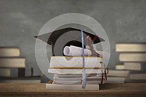 Graduation cap above stack books with degree paper