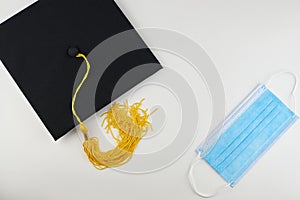 Graduation cap and medical mask on a white background. Proms in the context of the COVID-19 pandemic. Protection from the virus