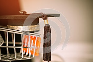 Graduation cap on store shop cart as metaphor for tuition and sc