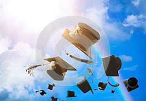 Graduation caps, hat thrown in the air with sun ray blue sky abs