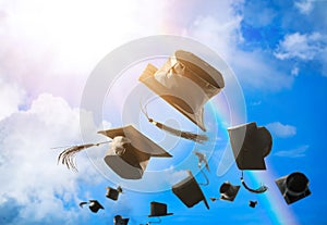 Graduation caps, hat thrown in the air with sun ray blue sky abs photo