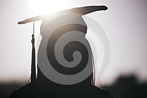 Graduation, education and silhouette of a student woman outdoor on university campus with lens flare. Future, college