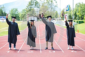 Graduation group of students celebrating on athletic track with