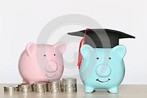 Graduation hat on blue piggy bank with stack of coins money on wooden background, Saving money for education concept