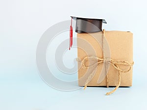 Graduation hat on brown paper gift box against blue  background, Congratulation graduated concept with copy space