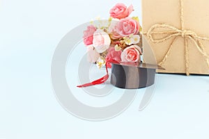 Graduation hat , brown paper gift box and flower against blue  background, Congratulation graduated concept with copy space