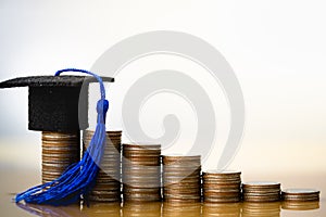 Graduation hat on coins money on white background.