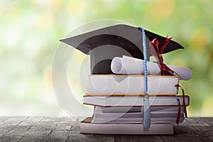 Graduation hat with degree paper on a stack of book