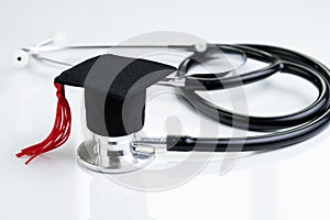 Graduation hat on doctor stethoscope, white background using as medical school, health care education or doctor`s university