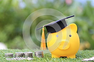 Graduation hat on golden piggy bank with stack of coins money on natural green background, Saving money for education concept