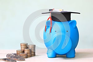 Graduation hat on piggy and stack of coins money on white background, Saving money for education concept