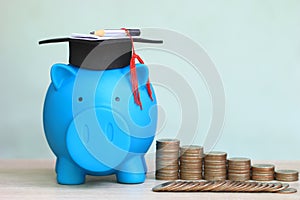 Graduation hat on piggy and stack of coins money on white background, Saving money for education concept