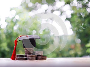 Graduation hat on stack of coins. The concept of saving money for education, student loan, scholarship, tuition fees in future