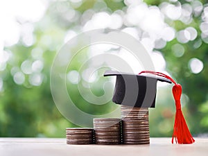 Graduation hat on stack of coins. The concept of saving money for education, student loan, scholarship, tuition fees in future