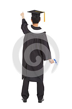 Graduation man wearing a mortarboard and pointing somewhere