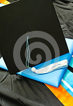 A graduation set with cap,tassel, gown, hood and diploma.