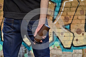 Graffiti artist with a spray can in his hand. Back view