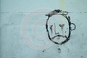 Graffiti, face of a sad looking man on a wall