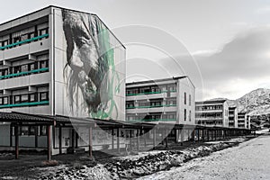 Graffiti with old shaman on the wall in living quarters with houses on the hill in the background Nuuk , Greenland