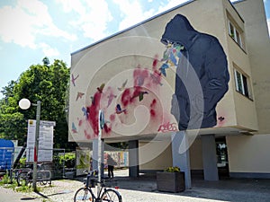 Graffiti of a building with a boy and hummingbird to Berlin in Germany.
