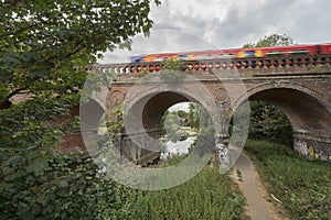 Graffiti under Leatherhead bridge with speeding train