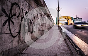 Graffiti on a wall and traffic moving over the Howard Street Bridge in Baltimore, Maryland.