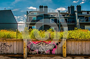 Graffiti on wooden fence in front of waterfronts condos in Point