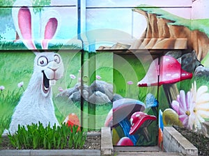 Grafitti of a happy Easter bunny in a meadow on a house wall