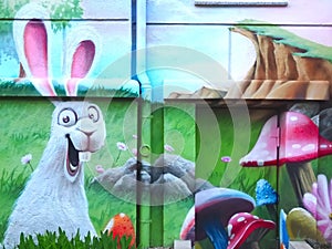 Grafitti of a happy Easter bunny in a meadow on a house wall