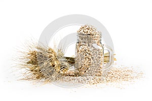Grain bouquet, golden oats spikelets and can filled with dried grains on white table. Food and jar