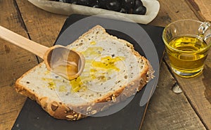 Grain bread cut into slices olive oil smeared with a wooden spoon by a female hand 2