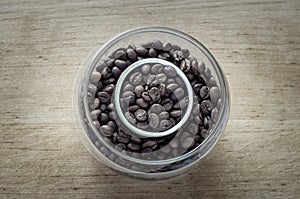 Grain coffee in round capacity. top view. wooden background