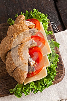 Grain croissant sandwich on a whiteboard and a dark background