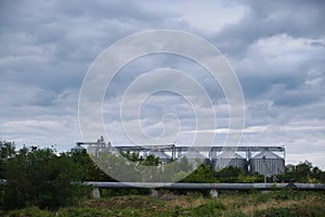 Grain elevator against the background of thickening gray clouds above it