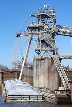 Grain elevator terminal spout loading corn into barge on Mississippi River